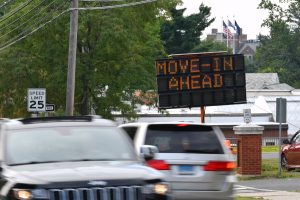 Cars along RT195 pass a sign announcing campus move in on Aug. 14, 2020. (Peter Morenus/UConn Photo)