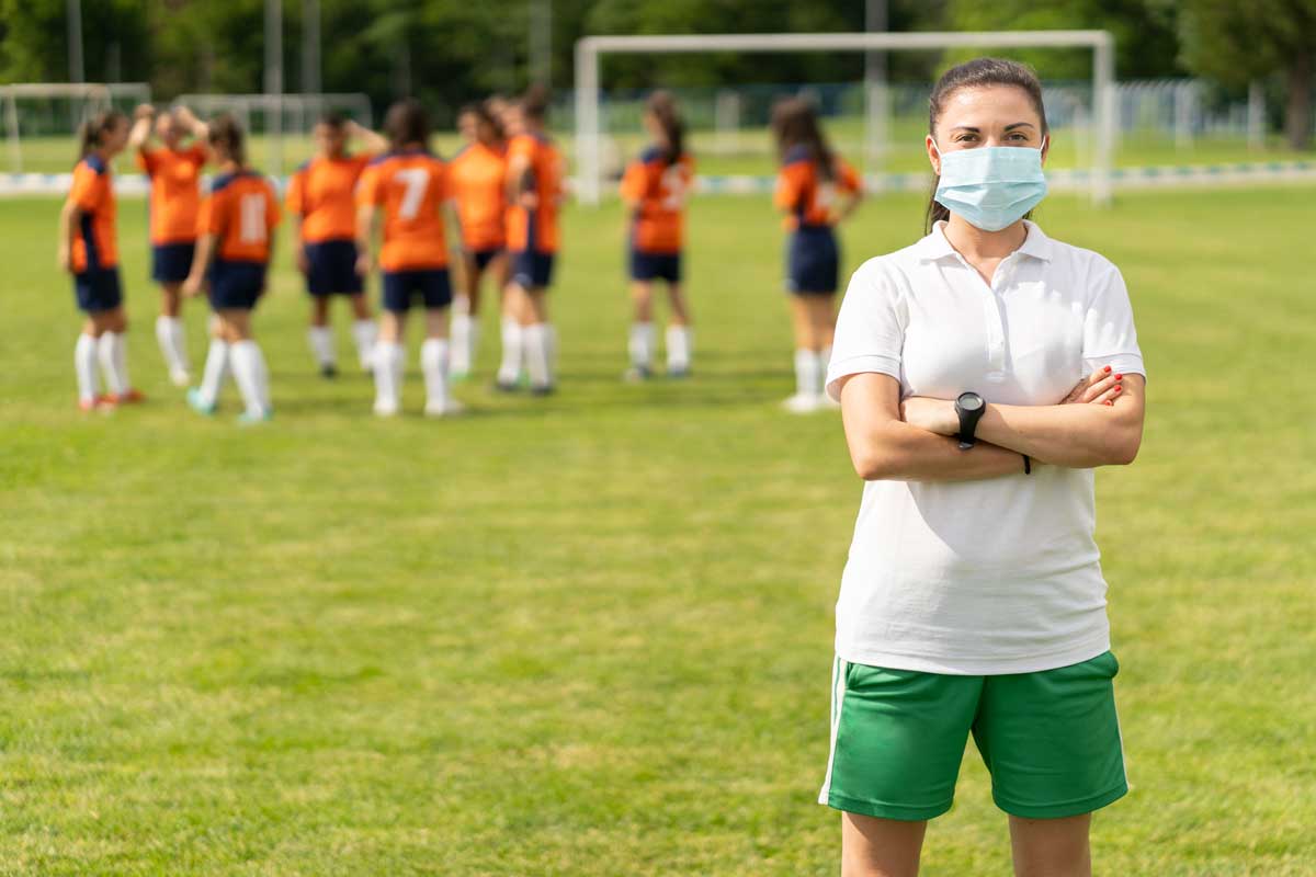 Young female soccer coach wearing surgical mask