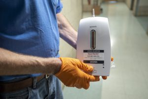 Maintenance team members Greg Messier of Facility Operations installing soap dispensers for the Chemistry Building on July 2. (UConn photo/SeanFlynn)