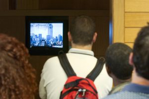 Students with their backs to the camera, facing a television showing live coverage of the September 11 terrorist attacks