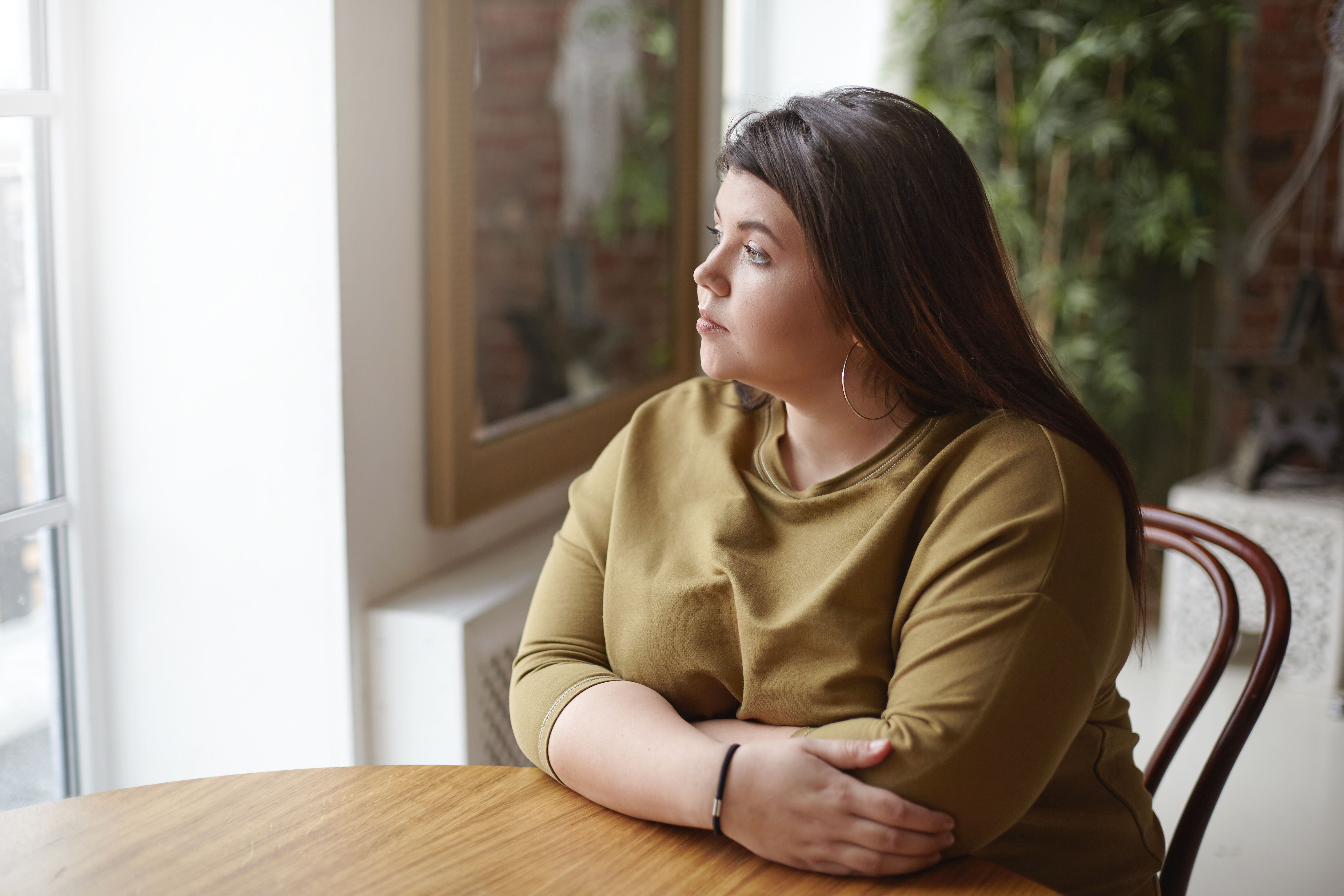 Overweight woman looks out window