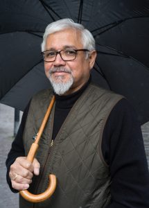 "Great Derangement" author Amitav Ghosh holding an umbrella.
