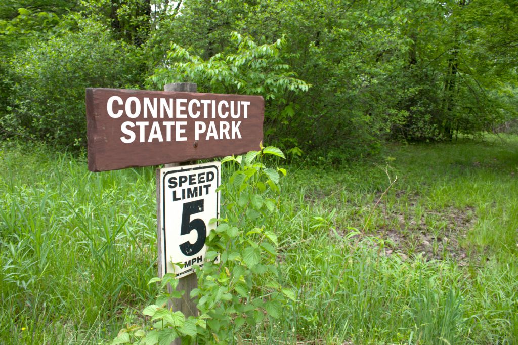A Connecticut state park sign pointing toward a hiking trail
