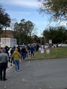 A long line of people wait outside at a polling location