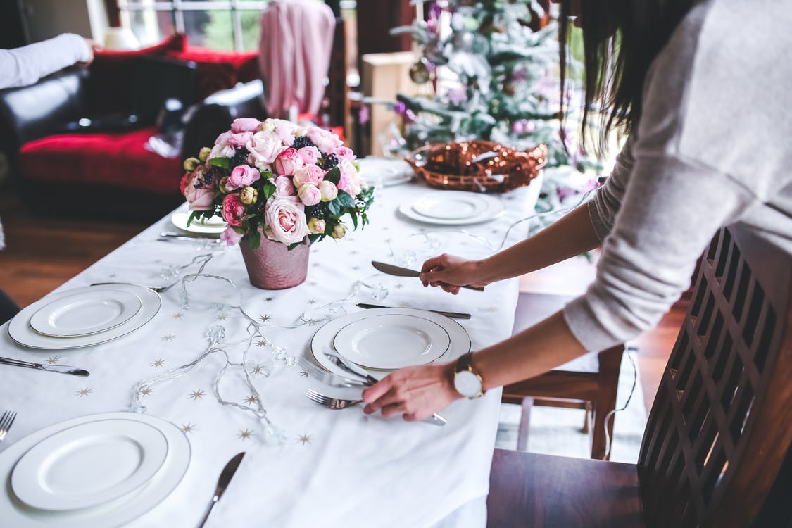 Woman sets table for holidays.