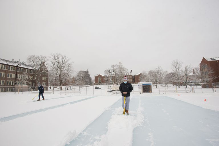 Students shoveling off snow at the outdoor ice rink on the Great Lawn on Jan. 27, 2021