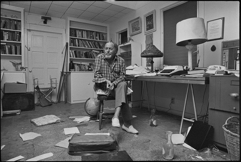 KEY WEST, FLORIDA, USA - 1982: American playwright Tennessee Williams (1911 - 1983) pictured at his desk with papers and various objects including half consumed bottles of wine in the office room of the house he owned in Key West, Florida, shortly before his death in 1983. A Tiffany lamp sits on the desk alongside a lamp with a dented shade and a typewriter. (Photo by Derek Hudson/Getty Images)