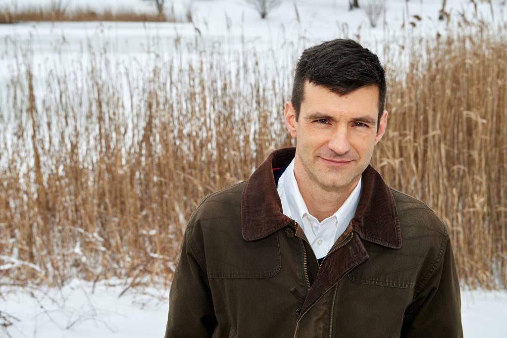 Mark Urban, professor of ecology and evolutionary biology, stands next to Swan Lake on Feb. 3, 2021