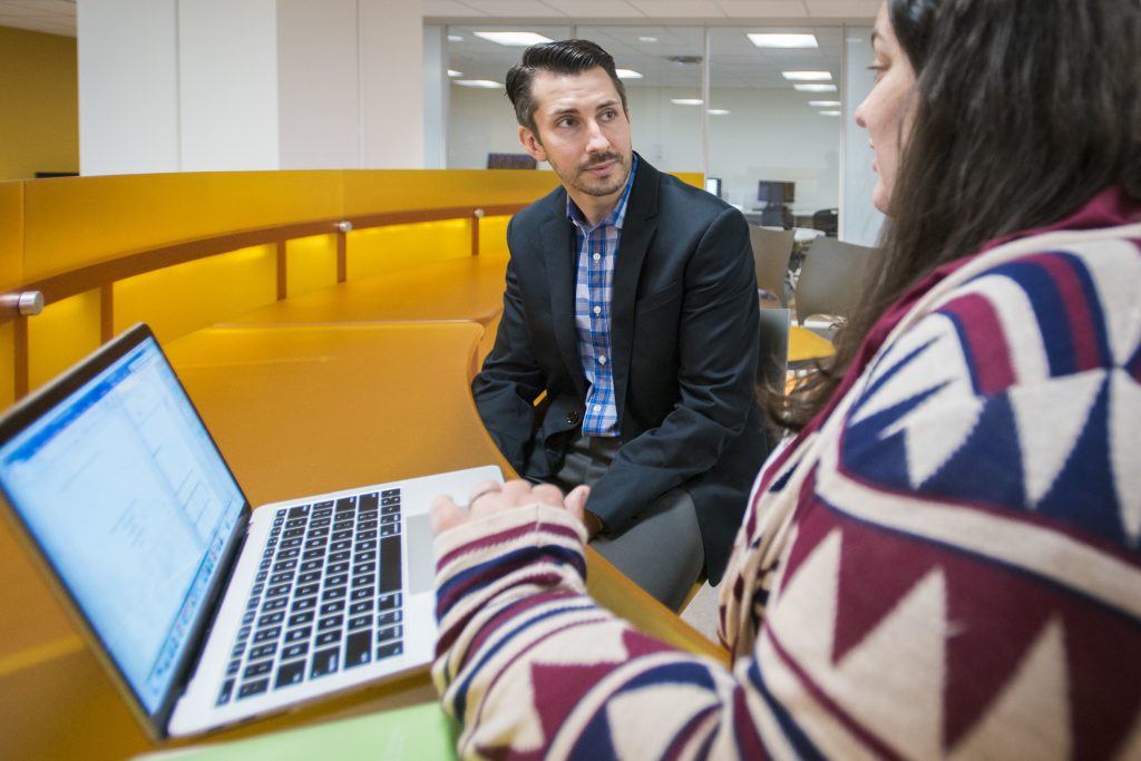 Social work assistant professor Nate Okpych speaks with a student