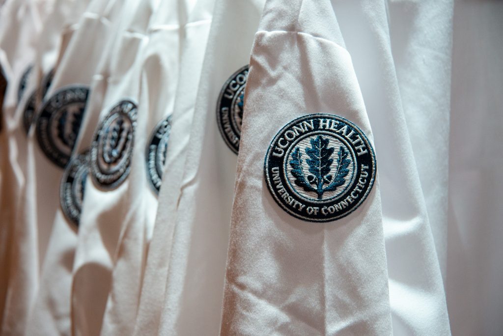 A closeup of the UConn Health logo patch on the shoulder of a white medical coat. Students at UConn Health participating in Match Day 2021 hailed the school's family atmosphere.