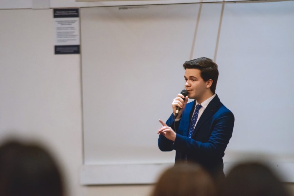 Alexander Mika '21 (CLAS) performs a stand-up comedy in a classroom.