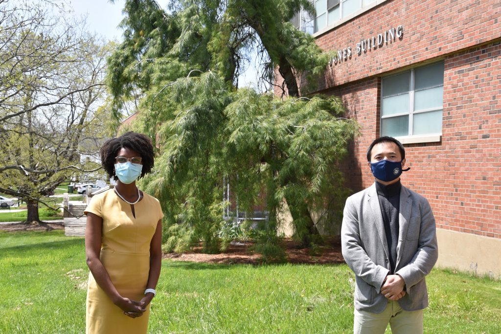 African American woman and Asian man stand outside