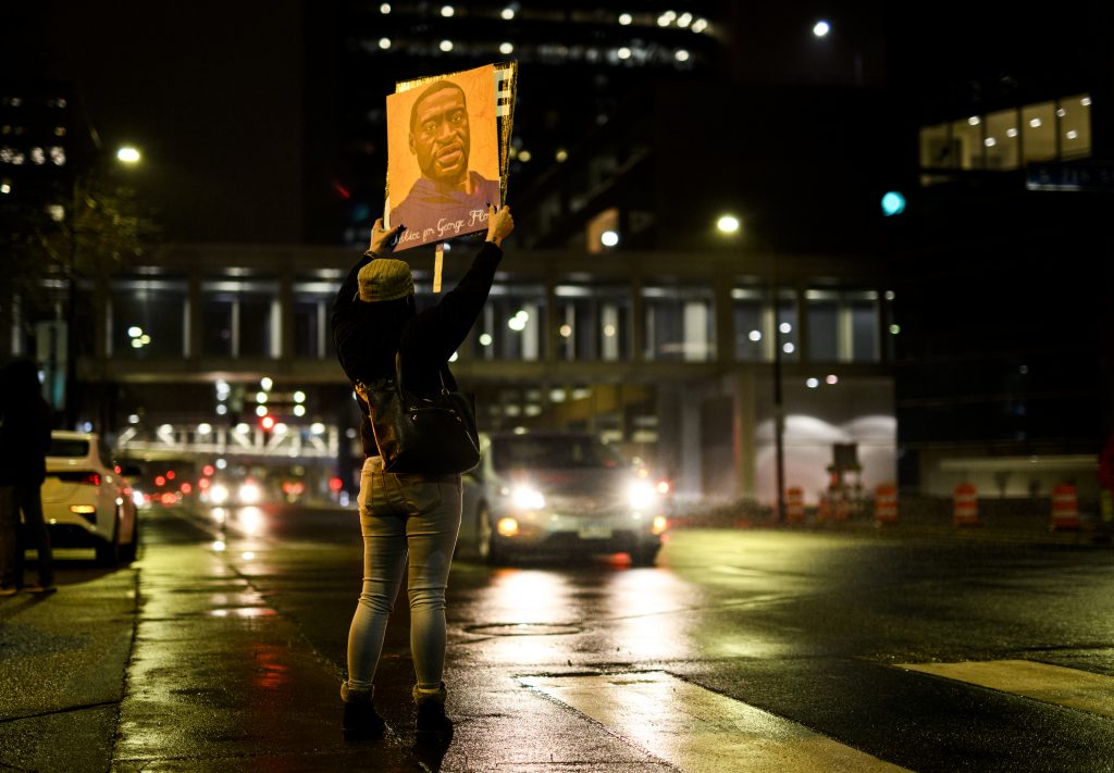 A woman holds up a portrait of George Floyd as people gather outside the Hennepin County Government Center on April 9, 2021 in Minneapolis, Minnesota. People demanding justice for George Floyd gathered tonight outside the Government Center, where the trial of former Minneapolis police officer Derek Chauvin has been ongoing for the past two weeks.