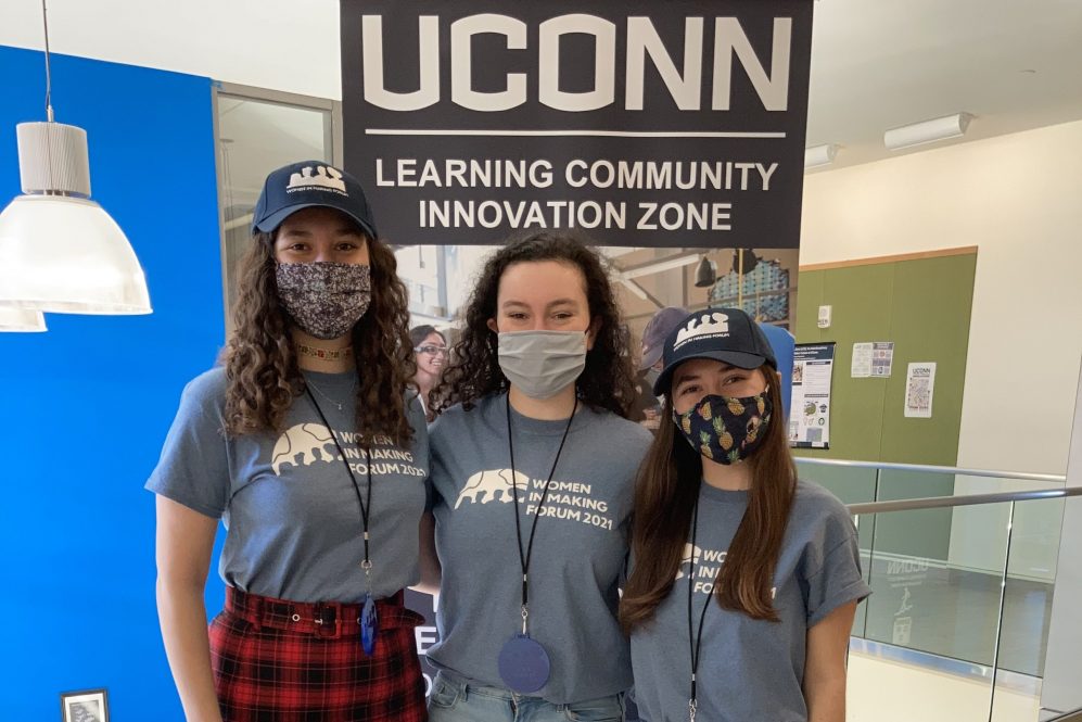 Three female students in masks smiling