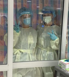 Two School of Nursing alumni are pictured in a hospital setting wearing personal protective equipment.