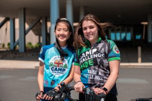 June Chu and Alex Estanislau in their cycling jerseys outside the academic entrance