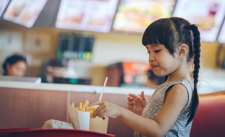 A child in a fast food restaurant. Voluntary policies at fast food restaurants have not increased the likelihood that parents will purchase healthier meals for children, according to new research.