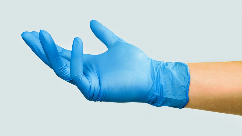 A hand wearing a blue medical glove.