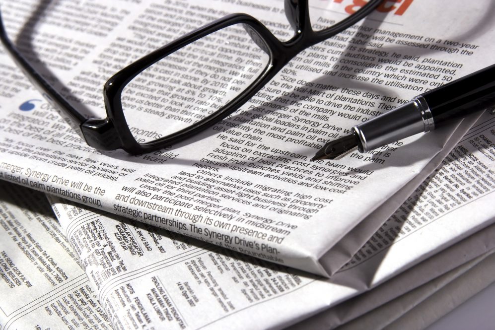 A pair of glasses sitting on a folded newspaper. Social work students who wrote letters to Connecticut newspapers say the experience helped improve their skills as social workers.