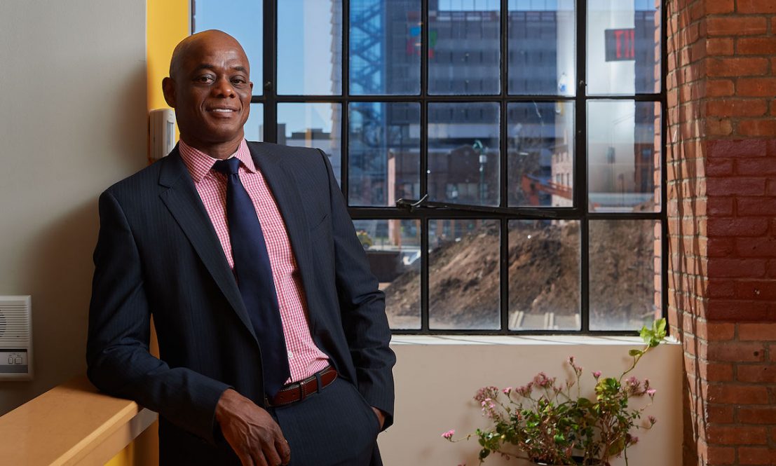 Freeman in his Hartford office with the Park and Main development under construction behind him.