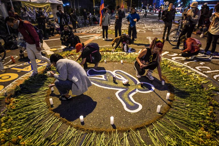 Women light candles during a protest against thousands of extrajudicial executions perpetrated by Colombian military forces, outside of The Special Jurisdiction for Peace (JEP) in Bogota on June 28, 2021. - Thousands of extrajudicial executions known as 