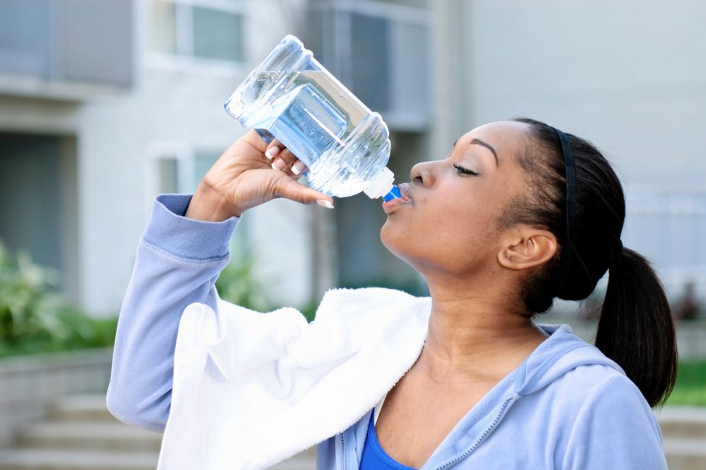 woman drinking water during exercise