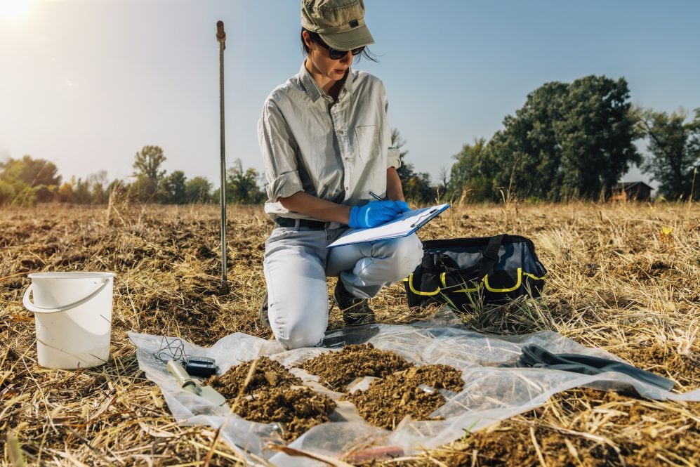 A scientist taking soil samples in a field. Field stations and marine laboratories are vital for scientists and the public, but the COVID-19 pandemic has jeopardized many of them.