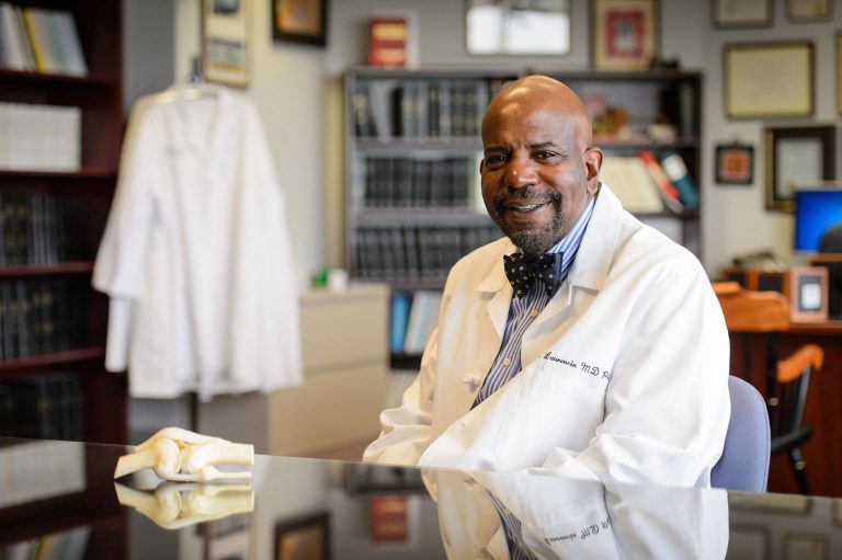 Dr. Cato T. Laurencin in white coat with anatomic model