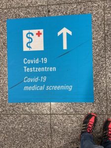 A sign in on the airport terminal floor in Frankfurt, Germany pointing to COVID testing.