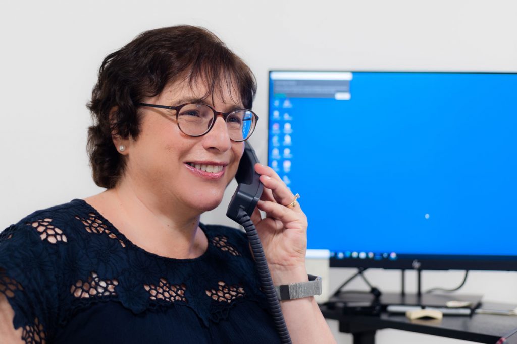 Social worker Sue Eisenberg speaking on an office phone