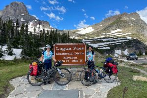 Alex Estanislau and June Chu with their bikes by the Logan Pass sign