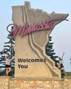Alex Estanislau and June Chu by the giant "Minnesota Welcomes You" sign
