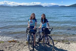 Alex Estanislau and June Chu with their bikes on the shore
