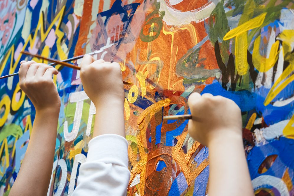 Kids hands with Colourful Paint Background. UConn Psychologist James Kaufman explains how to nurture creativity in kids.