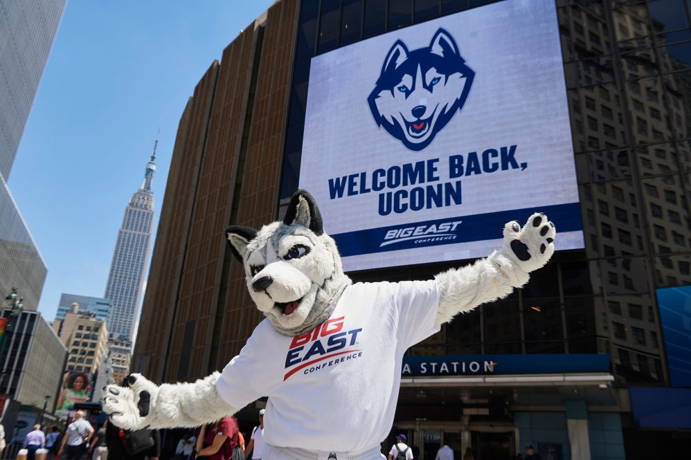 Jonathan the Husky poses for a photo near a marquee announcing UConn's return to the Big East athletic conference outside Madison Square Garden in Manhattan on June 27, 2019.