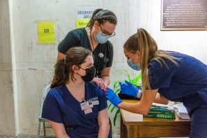 Nursing students practice injections on an orange.