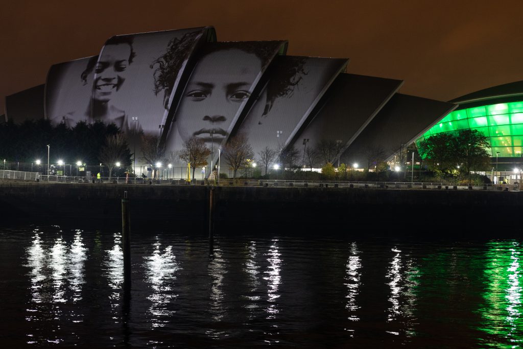 Faces of children appear during the projection of #ProjectingChange onto the exterior of SEC Armadillo on November 5, 2021 in Glasgow, Scotland. #ProjectingChange was an art activation created by world-renowned artists intended to inspire hope around the climate crisis during the 26th United Nations Climate Conference.