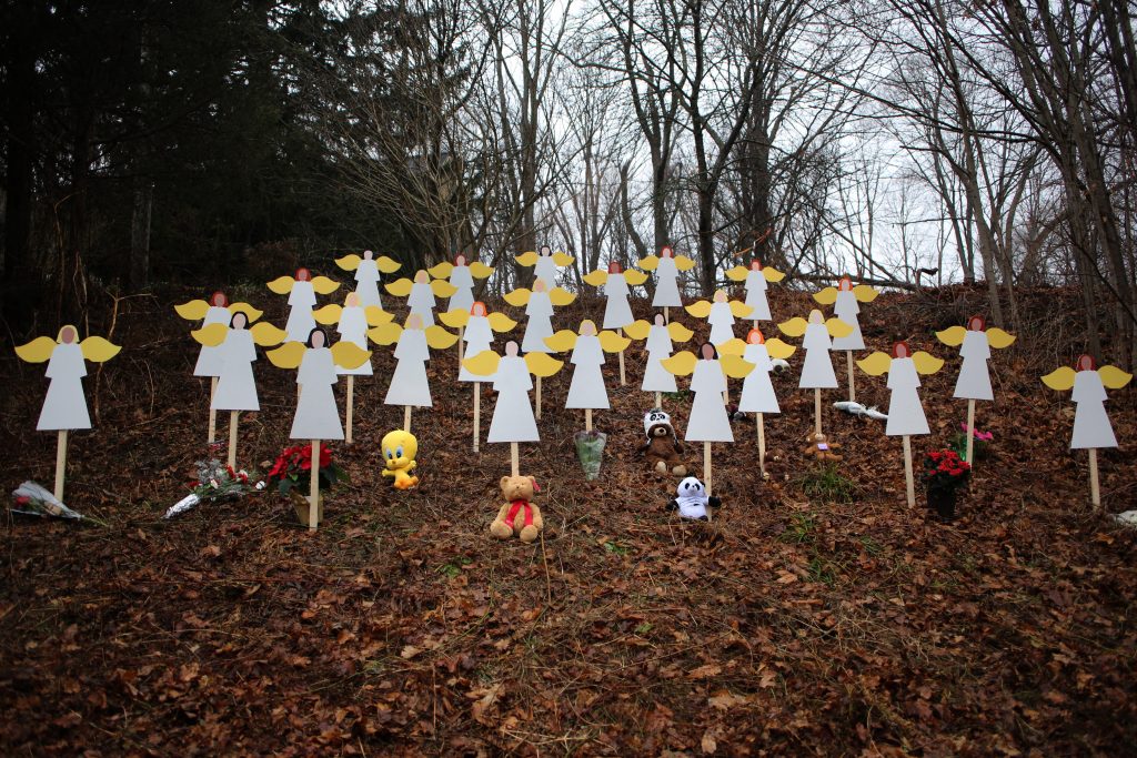 Twenty-seven wooden angel figures placed in a wooded area beside the road in Sandy Hook after the mass shootings at Sandy Hook Elementary School, Newtown, Connecticut, USA. 16th December 2012.