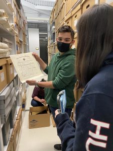 Joseph Vazquez ’22 shows a fellow student a document found in the Dodd Papers.