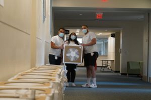 UConn School of Medicine Urban Health Scholars (from left) Rohit Makol '25, Samhita Gurrala '25, and Harrison Dieuveuil '25 show off one of the Corsi-Rosenthal boxes.