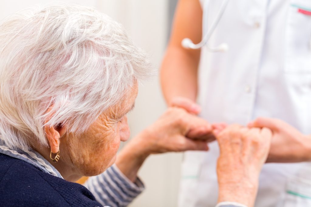 Young doctor giving helping hands for elderly woman.