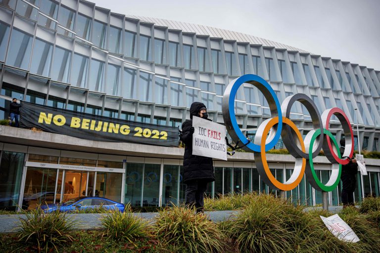 A Tibetan activist from the Students for a Free Tibet association holds a banner during a protest in front of the International Olympic Committee (IOC) headquarters ahead of the Beijing 2022 Winter Olympics, on December 11, 2021 in Lausanne. - Human rights campaigners and exiles accuse Beijing of religious repression and massively curtailing rights in Tibet. (Photo by VALENTIN FLAURAUD/AFP via Getty Images)
