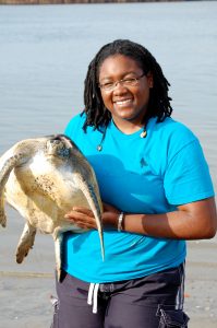 Smiling woman holding a turtle