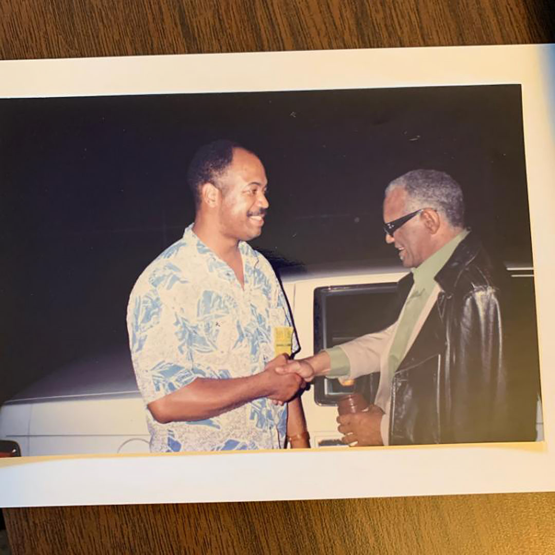 Photo of Dwayne Proctor and Ray Charles shaking hands while on tour in the 1980s.