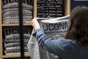 Woman holds up UConn School of Social Work sweatshirt.