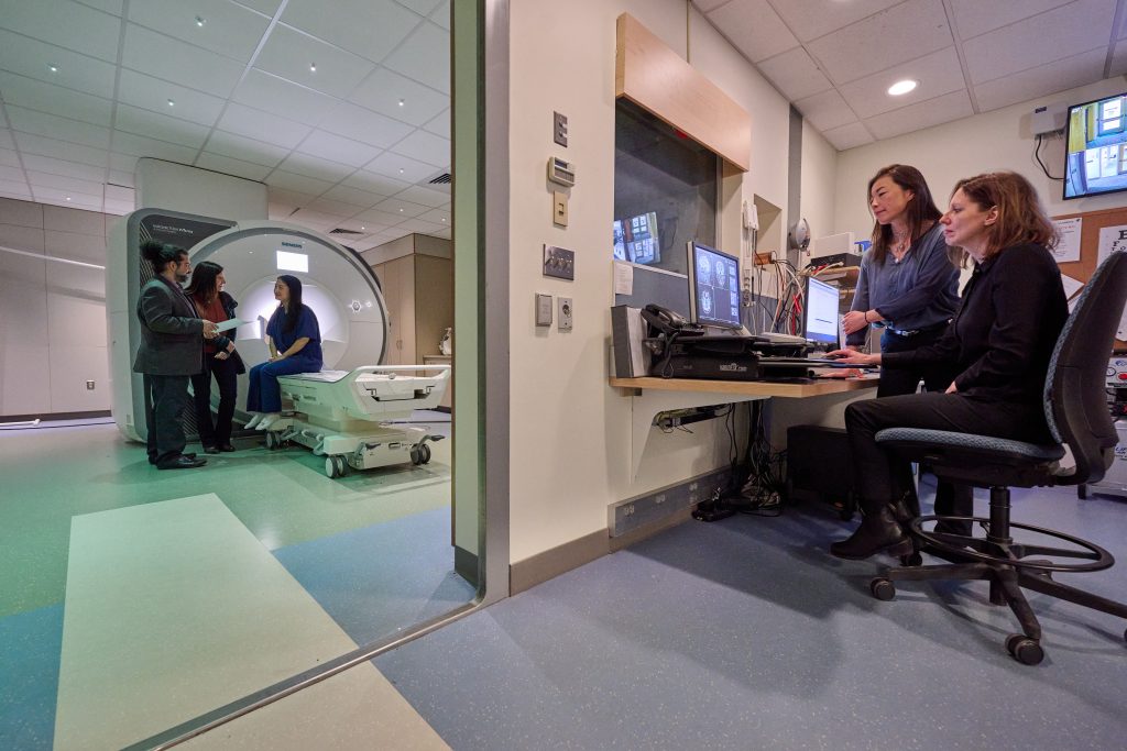 Arash Esmaili Zaghi, left, associate professor of civil and environmental engineering, left, Fabiana Cardetti, professor of mathematics, and Jie Luo, a graduate student, with the fMRI, and Fumiko Hoeft, professor of psychological sciences, Nicole Landi, associate professor of psychological sciences, are in the control room at the UConn Brain Imaging Research Center on March 7, 2022.