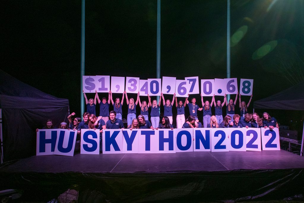 HuskyTHON participants holding up cards with the total dollar amount raised during this year's dance marathon
