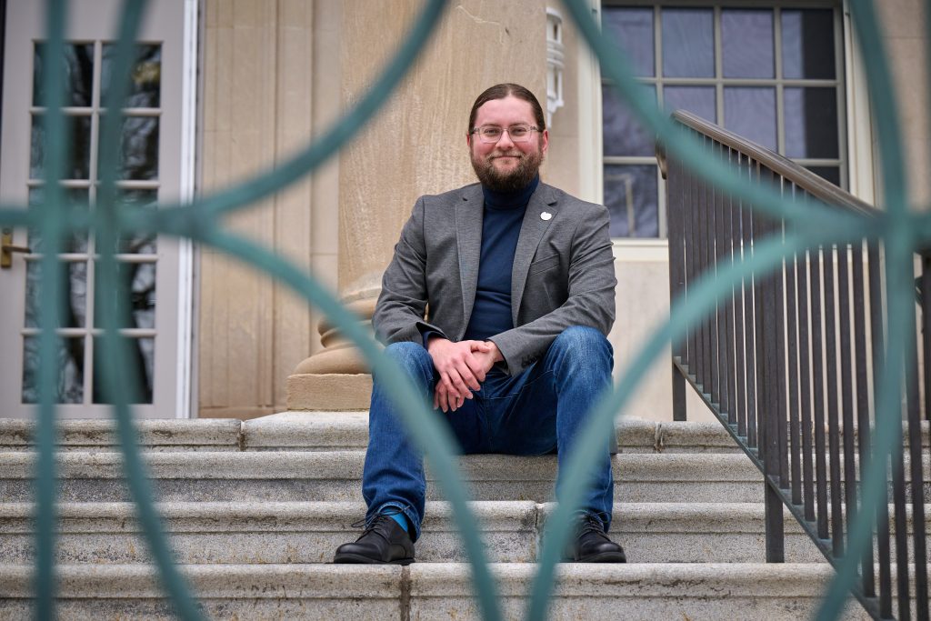 Michael Rodriguez sits on the steps of the Wilbur Cross Building on April 7, 2022.