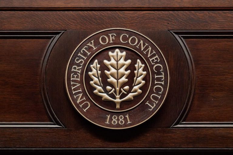 The official University of Connecticut seal, in painted gold on an oak panel.