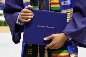 A degree candidate holds a diploma case during the School of Engineering Commencement ceremony at Gampel Pavilion on May 5, 2018.